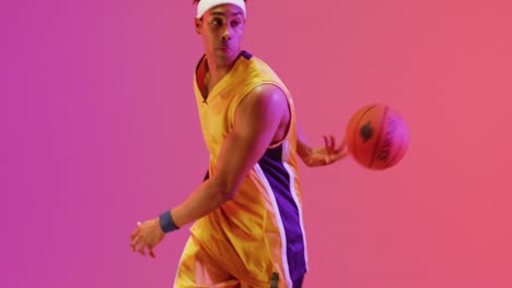Video-Eines-Gemischtrassigen-Männlichen-Basketballspielers,-Der-Einen-Ball-Auf-Orangefarbenem-Bis-Rosafarbenem-Hintergrund-Wirft
