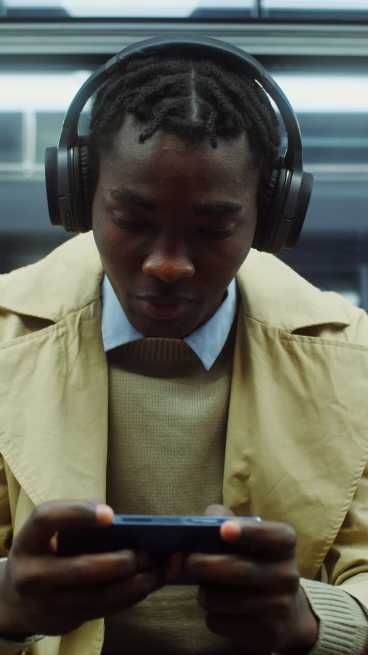 Man Using Smartphone with Headphones on a Train