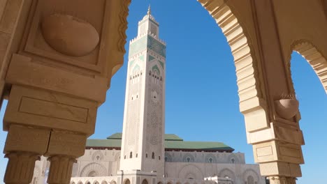 archway tilt down view to hassan ii mosque's minaret, casablanca morocco