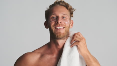 man with eye patches holding towel on his shoulder