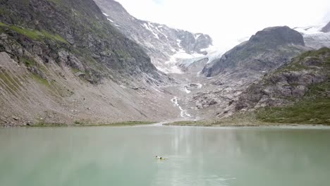 vuelo de drones lago y glaciar stein con hombre en colchón de aire en los alpes urner en suiza