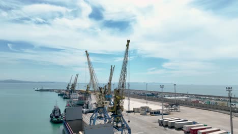 aerial shot of loading cranes in a seaport standing still waiting for cargo