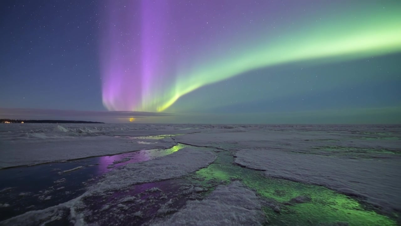Dansende nordlys vokser etter en magnetisk bølge over en polar kyst, og reflekteres i smeltevannsbassenger