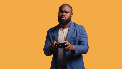 Portrait-of-cheerful-man-playing-videogames-with-controller,-studio-background