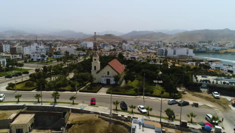 Aerial-view-toward-the-Iglesia-La-Resurrección-del-Señor-church-San-Bartolo,-in-sunny-Peru,-South-America