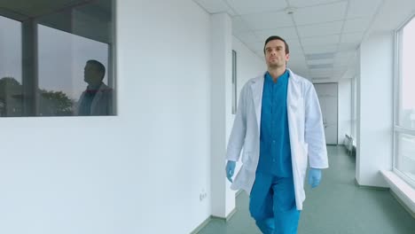 medical worker walking in white corridor. male doctor walking hospital corridor