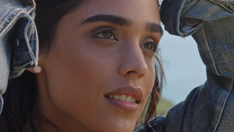 close-up-portrait-of-beautiful-indian-woman-enjoying-peaceful-sunny-day-relaxing-on-summer-vacation-running-hands-through-hair