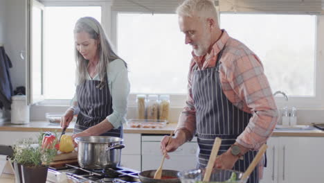 Pareja-Caucásica-De-Mediana-Edad-Cocinando-Juntos-En-La-Cocina-De-Casa,-Cámara-Lenta