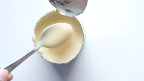 open can of condensed milk with spoon