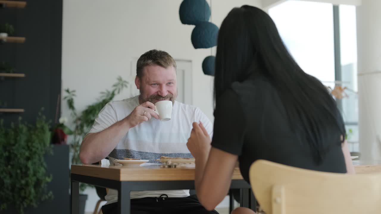 커플 이 카페 에서 커피 와 대화 를 즐기고 있다