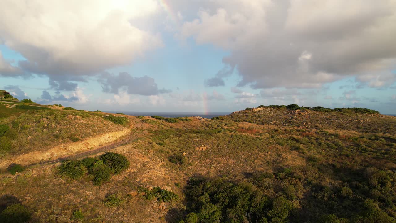 volando sobre la colina de las islas vírgenes británicas y revelando el arco iris sobre el horizonte del mar del caribe