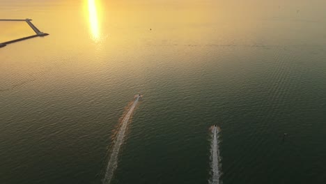 stunning 4k drone footage of two speedboats slicing through golden waters at sunset off the kuwait coast. ideal for travel, nature, lifestyle, and cinematic projects.