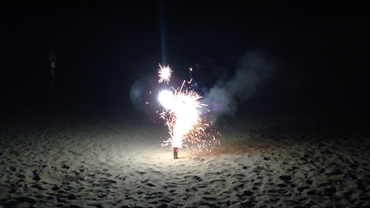 pequeños fuegos artificiales que estallan alrededor del 4 de julio en la playa, oregon, por la noche.