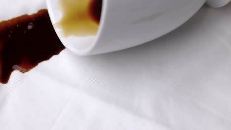 tazas de café calientes derramadas en una camisa blanca. una camisa de algodón blanca manchada de café marrón