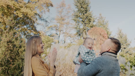 Happy-couple-playing-with-their-little-daughter-in-the-park.-Having-a-good-time-together