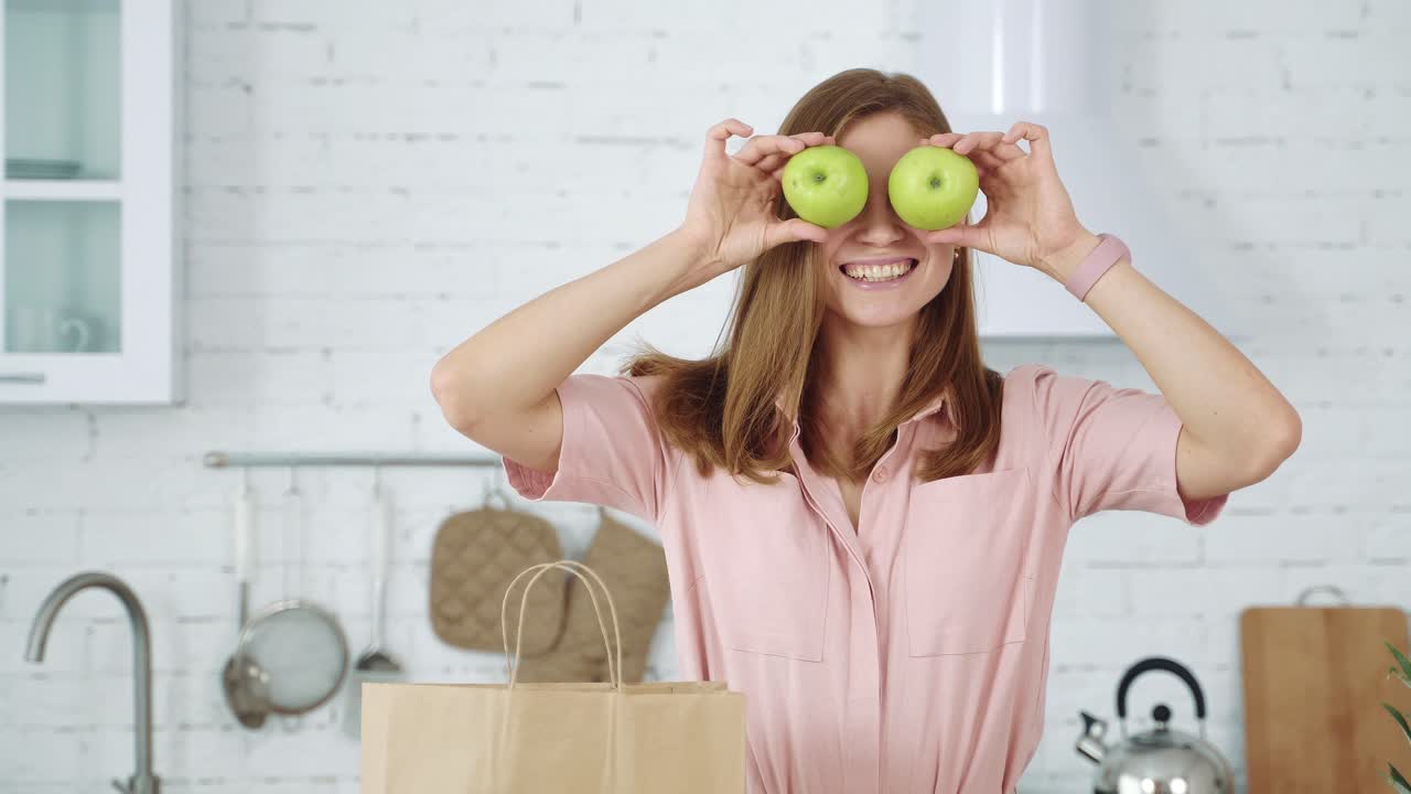 Young girl closes her eyes with green apples. Healthy eating