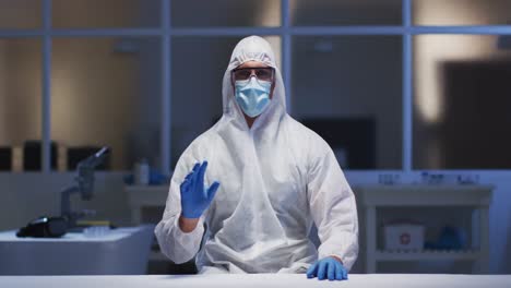 caucasian male medical worker wearing protective clothing and mask using virtual digital interface i