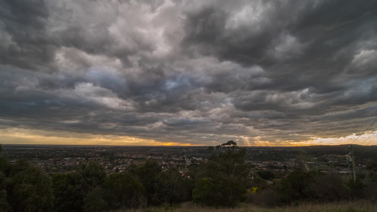 un hermoso lapso de tiempo con un ligero zoom sobre increíbles nubes de tormenta con una puesta de sol sobre la ciudad de melbourne