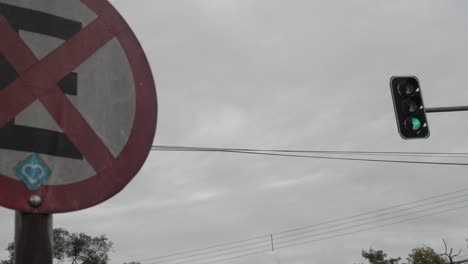 Traffic-light-turning-green-with-a-no-stop-sign-on-the-foreground