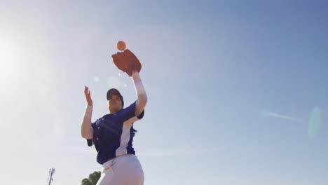 Mixed-race-female-baseball-fielder-catching-and-dropping-ball-on-sunny-baseball-field