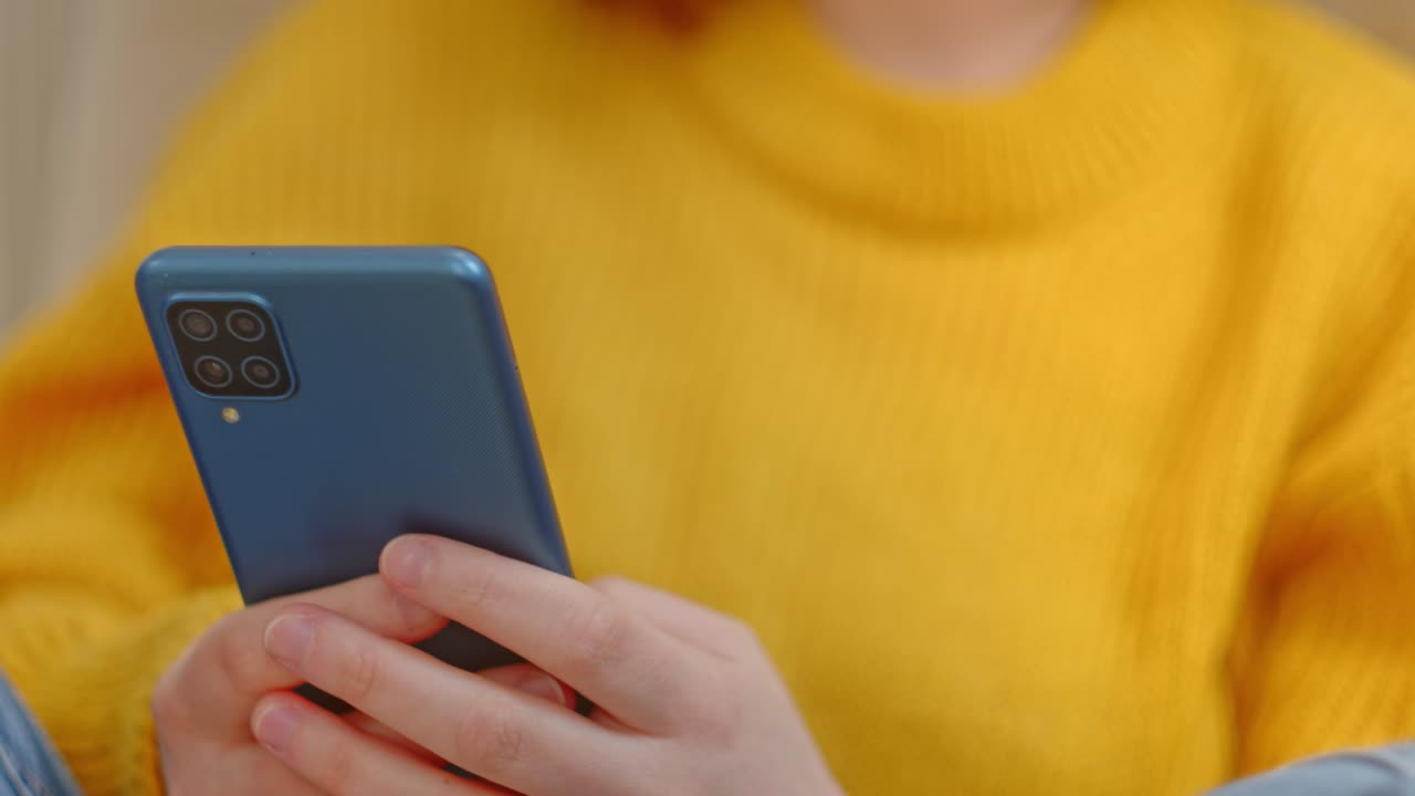 chica enviando mensajes de texto en un teléfono inteligente azul con 4 cámaras