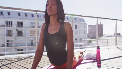 persona de raza mixta de género fluido practicando meditación de yoga en la terraza del techo