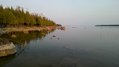 Aerial-orbit-of-coastal-lake-view-at-goldenhour-and-calm-water