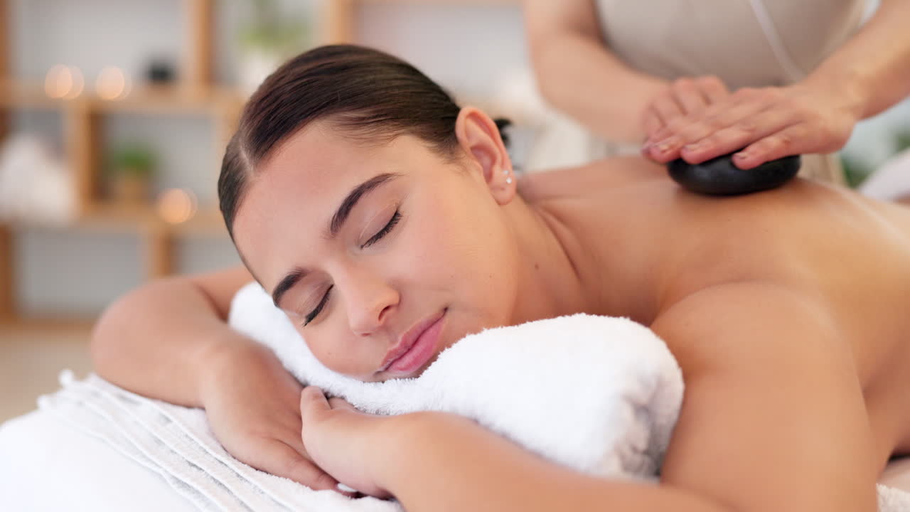 una mujer disfrutando de un masaje con piedras calientes.