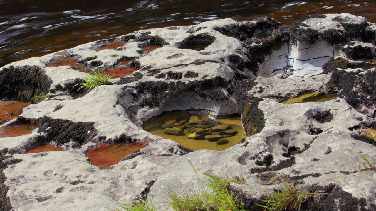 tiro ancho de piedra caliza agujeros de queso suizo con agua y grava en el interior