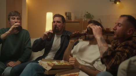 amigos disfrutando de pizza y cerveza en casa