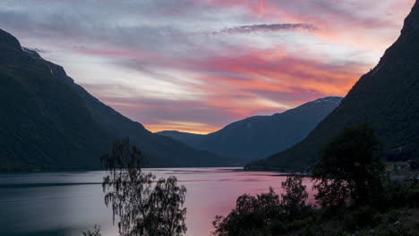 cielo colorido durante la puesta de sol sobre el fiordo y las montañas cerca del pueblo de leon en stryn, vestland, noruega