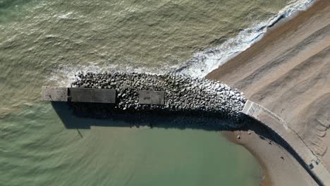 drone shot of hastings uk, top down shot flying over land based fishing fleet wave breaker