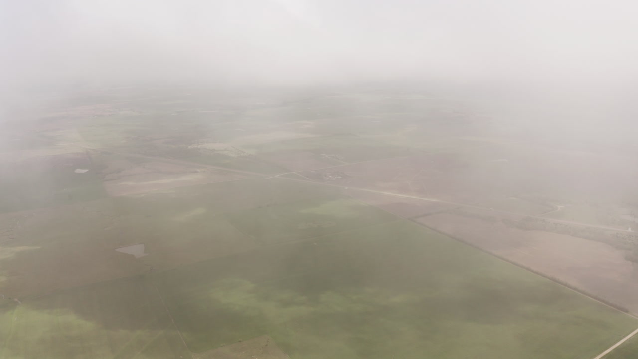 드론은 미국 중서부의 초원과 농지 위의 구름을 통과합니다.