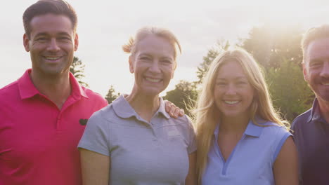 retrato de parejas maduras y adultas de pie en un campo de golf jugando juntos