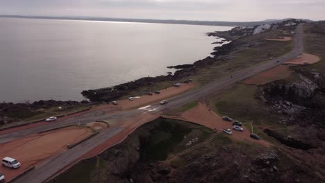 cars parking along coastal and panoramic road ocean view, punta ballena peninsula in uruguay