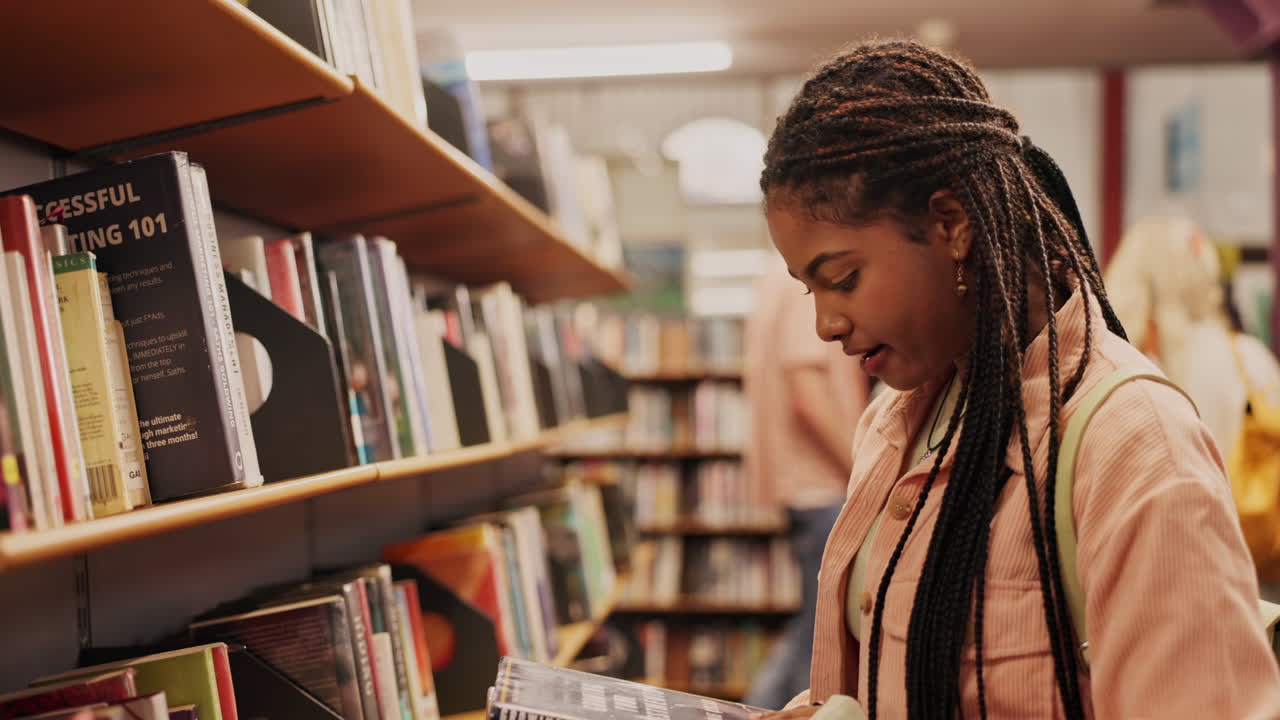 A young woman browsing through books in a library