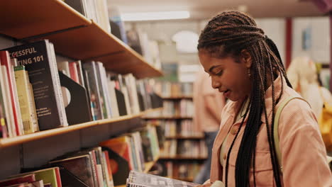 a young woman browsing through books in a library