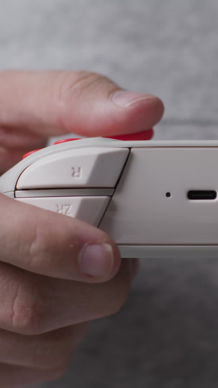 video frontal vertical en primer plano mano disparada hombre jugando controlador de videojuego