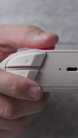 video frontal vertical en primer plano mano disparada hombre jugando controlador de videojuego