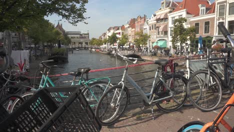 bicicletas estacionadas en el puente sobre el río de la ciudad de leiden, escena urbana holandesa por excelencia