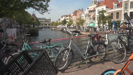 bikes parked on bridge over leiden city river, quintessential dutch urban scene