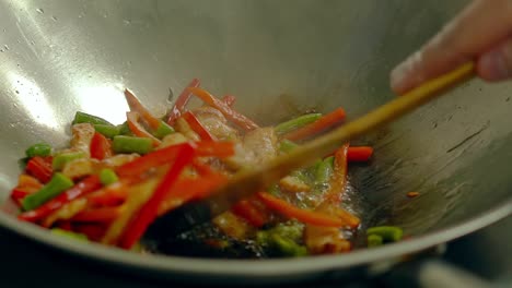 cook prepares fresh vegetables in a frying pan in boiling oil stir with a wooden spatula 1