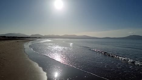 hazy snowdonia mountain range across idyllic slow motion shimmering irish ocean