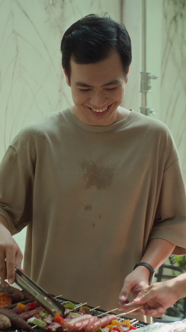 Vertical of Man Making Grilled Sausages and Skewers Outdoors