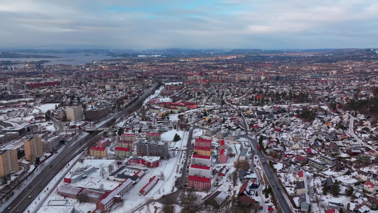 Linderudkollen Oslo Fjord Norge Norway aerial drone Gamle Tonsengagen Bjerke Arvoll morning buildings cars traffic highway roads snowing cold cloudy winter day gray skies forward pan up