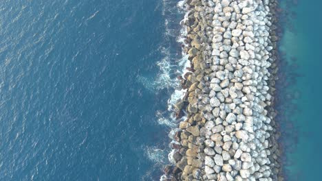 Pared-De-Roca-Playa-Redonda-|-Océano-Azul-Claro-|-Hora-Del-Día-|-Tiro-Ascendente-Desde-Arriba