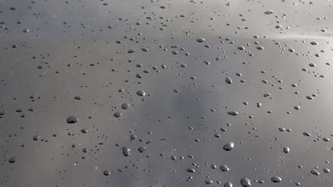 close up view at rain drops falling on a glass surface