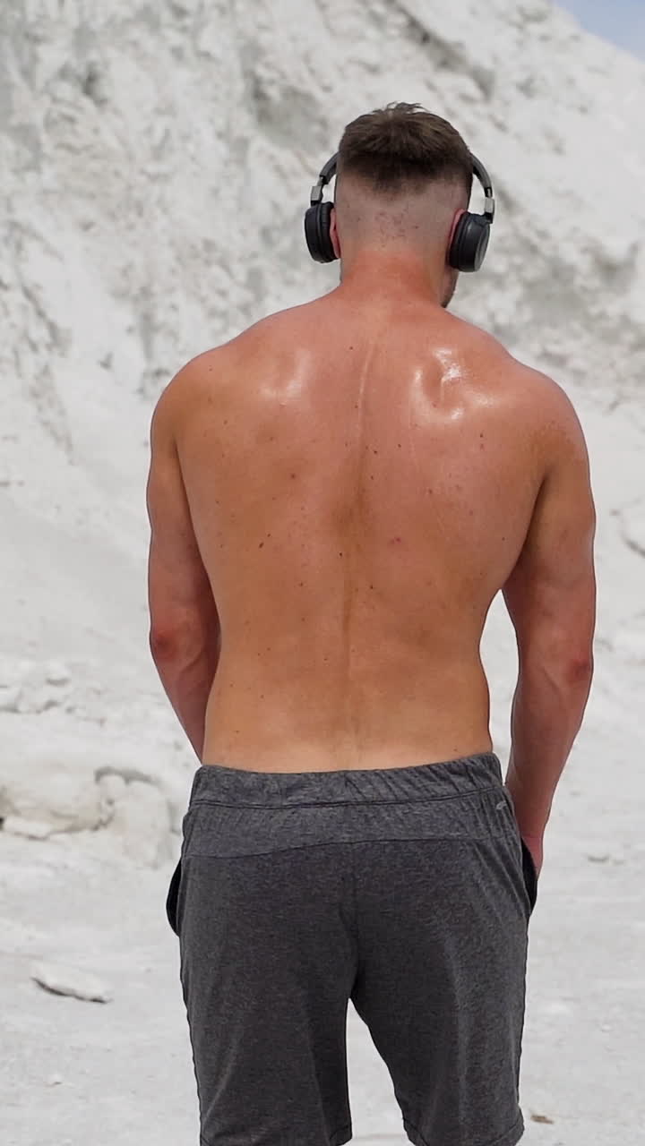 Getting motivated for hard workout. Man listening to the music with headphones for training Vertical video