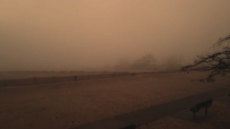 A-distant-lighthouse-covered-in-orangey-mist-off-of-Lake-Michigan