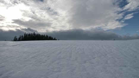 Winter,-Schneebedeckter-Berghügel,-Umgeben-Von-Bäumen-Und-Wolken